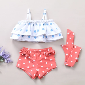 Detailed flat lay of toddler polka dot swimsuit set with ruffles and a cute bow