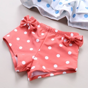 Detailed view of pink polka dot swimsuit bottoms with decorative bows for toddlers