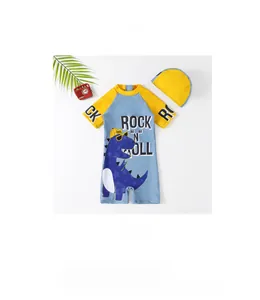 Detail of blue and yellow boys' dinosaur swimsuit with a matching swim cap on a white base