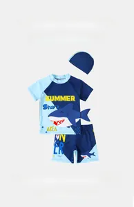 Detailed flat lay of boys shark swimsuit set with short sleeve top and matching swim cap