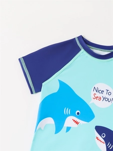 Detail of boys short sleeve swim shirt with blue shark print and Nice To Sea You text