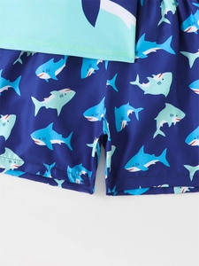 Close-up of boys swimwear featuring elastic waistband and cartoon shark print pattern