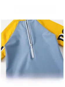 Detail of smooth front zipper and blue-yellow stitching on boys cartoon swimsuit