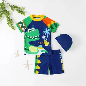 Three-piece boys dinosaur swimwear set with short sleeve rash guard, shorts and swimming cap
