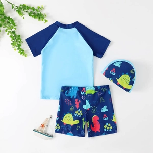 Three-piece boy's swimsuit set with blue dinosaur prints including top, shorts and a cap