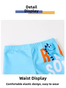 Detail of kids swim trunks showing elastic waistband and cute dinosaur cartoon print