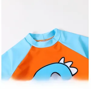 Detail view of the round collar and cartoon dinosaur print on kids swimwear