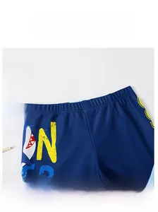 Detail of dark blue swim shorts with elastic waistband and shark print for kids