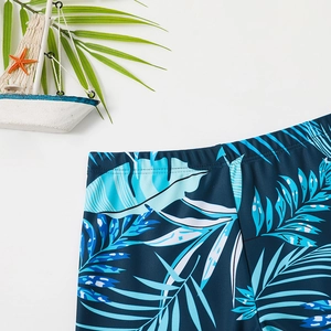 Detail of boys' dinosaur swim shorts with tropical palm leaf print and elastic waistband