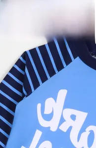 Detail of blue boys swimwear featuring shark graphics and high-quality flatlock stitching