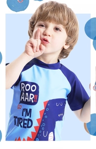 Detail of boys' short sleeve blue dinosaur print swimwear with color block raglan sleeves