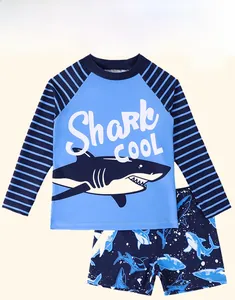 Detail of kids long sleeve swimwear set featuring cartoon shark print and wave patterns