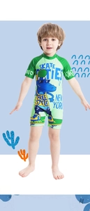 Detail of short sleeve boys' swimsuit featuring a blue crocodile print and secure zipper