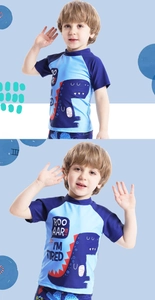 Detailed view of kids dinosaur print swim shirt with blue paneling and funny typography