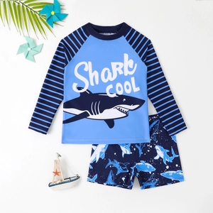 Two-piece boys long sleeve swimsuit with shark print and navy stripes on white background