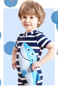 Detail of boys' navy striped one-piece swimsuit featuring a cute shark cartoon print