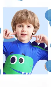 Close-up of blue kids swimsuit featuring green cartoon dinosaur and 3D purple spikes