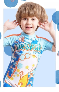 Close-up of a boy wearing a blue dinosaur print short-sleeve one-piece swimsuit