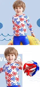 Detail of boys' long-sleeved swimsuit featuring blue-red bow print and striped shorts