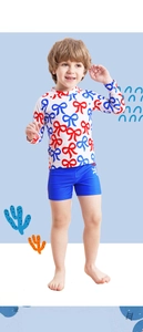 Detail of boys' long-sleeve swimwear featuring red and blue bow prints and elastic shorts