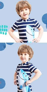 Detail of boys' short sleeve swimsuit featuring blue stripes and cartoon shark print