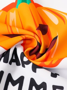 Detail of pumpkin print and HAPPY SUMMER text on elastic kids swimwear fabric
