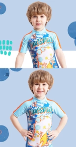 Close-up of boys short sleeve swimsuit featuring a cartoon dinosaur print and blue fabric