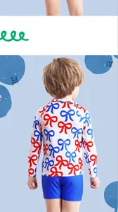 Detail view of boys' long-sleeve swimwear featuring all-over bow tie print and blue shorts