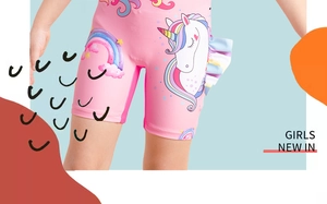Detail of pink girls swimsuit with unicorn and rainbow prints and side ruffles