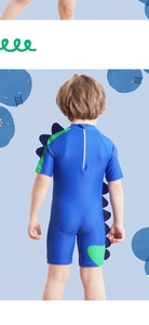 Detail view of boys dinosaur swimsuit featuring back zipper and 3D blue fin accents