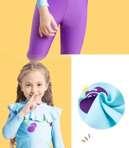 Detail of girls long sleeve swimwear with cherry print and ruffle collar on yellow background