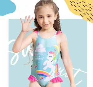 Detail of blue unicorn swimsuit with pink ruffles and 'Unicorns are awesome' print