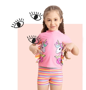 Close-up of pink girls' swimwear with unicorn print and rainbow striped bikini bottoms