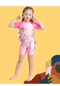 Close-up of pink girls one-piece swimsuit featuring unicorn pattern and ruffle details