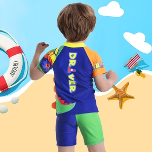 Three-piece dinosaur themed boys' swimwear with blue short sleeves and 3D fin details