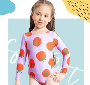 Detail of girls long sleeve swimsuit with vibrant orange tomato print on purple fabric