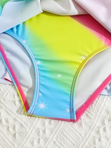 Detail eines Mädchen-Badeanzugs mit Regenbogen-Farbverlauf und Sternenmuster
