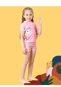 Close-up of unicorn print and colorful ruffle detail on pink girls' swimsuit top