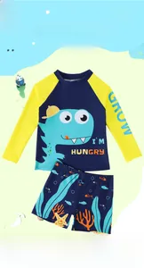 Détail de maillot de bain garçon à manches longues avec motifs dinosaure et marin