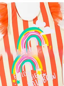 Close-up of red striped girls swimsuit featuring rainbow print and orange mesh ruffles