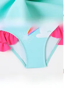Detail of blue swimsuit featuring pink ruffle trim and rainbow star cartoon prints