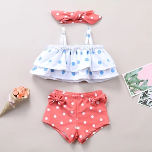 Detailed flat lay of toddler girl's three-piece swimwear with ruffles and polka dots