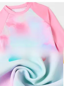 Detail of girls' long sleeve swimwear featuring palm tree print and pink tie-dye fabric
