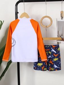 Dettaglio di costume da bagno bimbo a maniche lunghe con pantaloncini stampa dinosauri