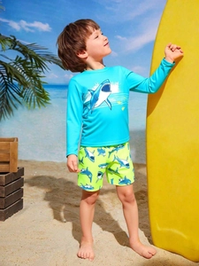 Detail van blauwe haaien rashguard voor kinderen en groen bedrukte zwembroek