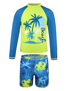 Close-up of quick-dry kids' swimwear featuring tropical palm tree prints and Beach logo