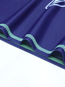 Detail of high-elastic navy fabric with bright green contrast flatlock stitching