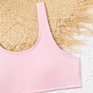 Top bikini rosa a coste per bambina con spalline larghe su cappello di paglia per l'estate