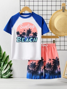 Detail eines zweiteiligen Jungen-Badeanzugs mit Palmenprint und Surfing-Beach-Grafik