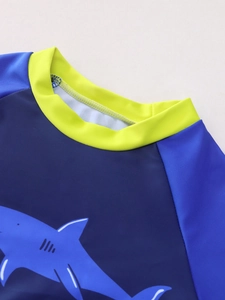 Dettaglio maglia nuoto bambino con colletto giallo e stampa squalo a contrasto